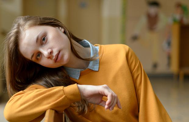 teen girl leaning on back the back of her chair