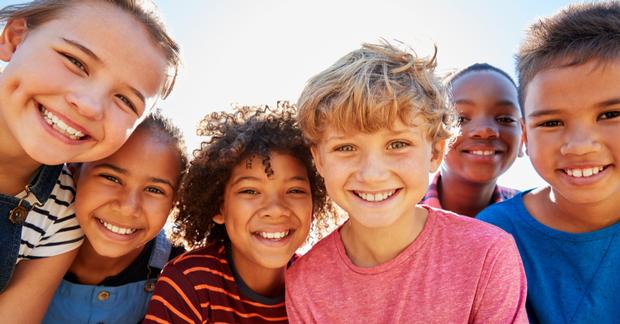 diverse group of smiling third-grade schoolchildren 